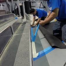 Workers installing flooring with blue tape.