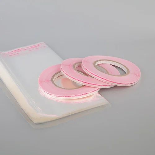 Pink adhesive tape rolls on grey background.