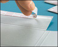 Hand peeling adhesive strip from envelope.