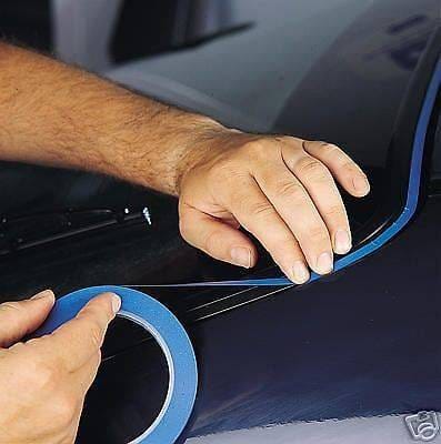 Applying blue masking tape to surface.