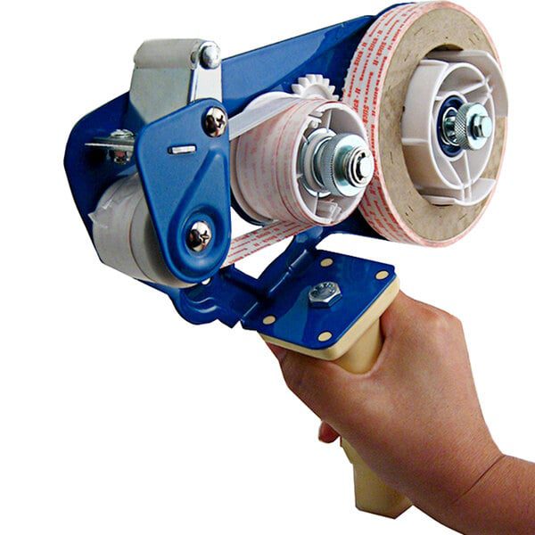 Hand holding a blue packing tape dispenser.