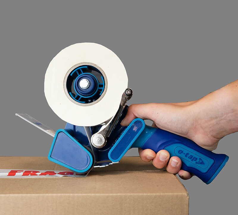 Hand using tape dispenser on box.