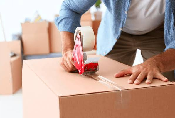 Sealing a cardboard box with tape.