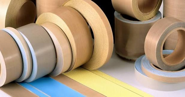Pile of rolls of brown and blue tape sitting on top of a white table